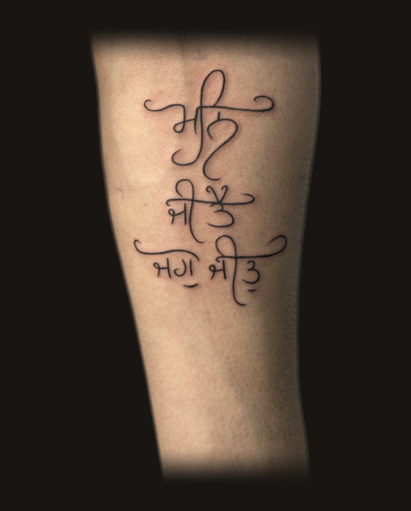 Gurmukhi script, fine line tattoo on a forearm